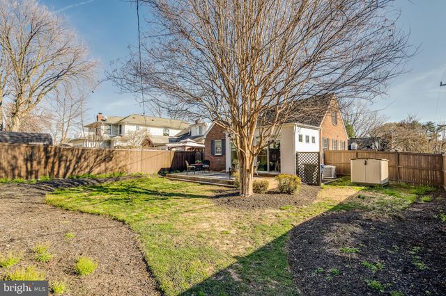 a view of a city with tall buildings and a clock tower in middle of a field