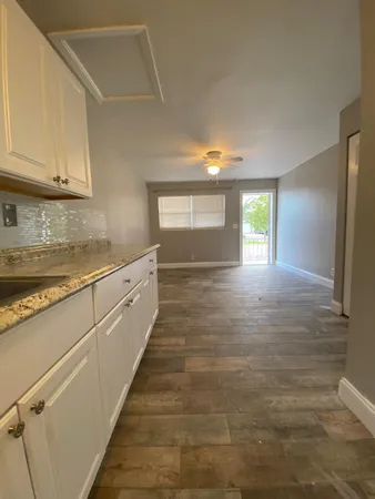 a large white kitchen with sink and cabinets