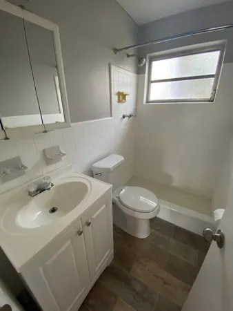 a bathroom with a toilet a sink and mirror
