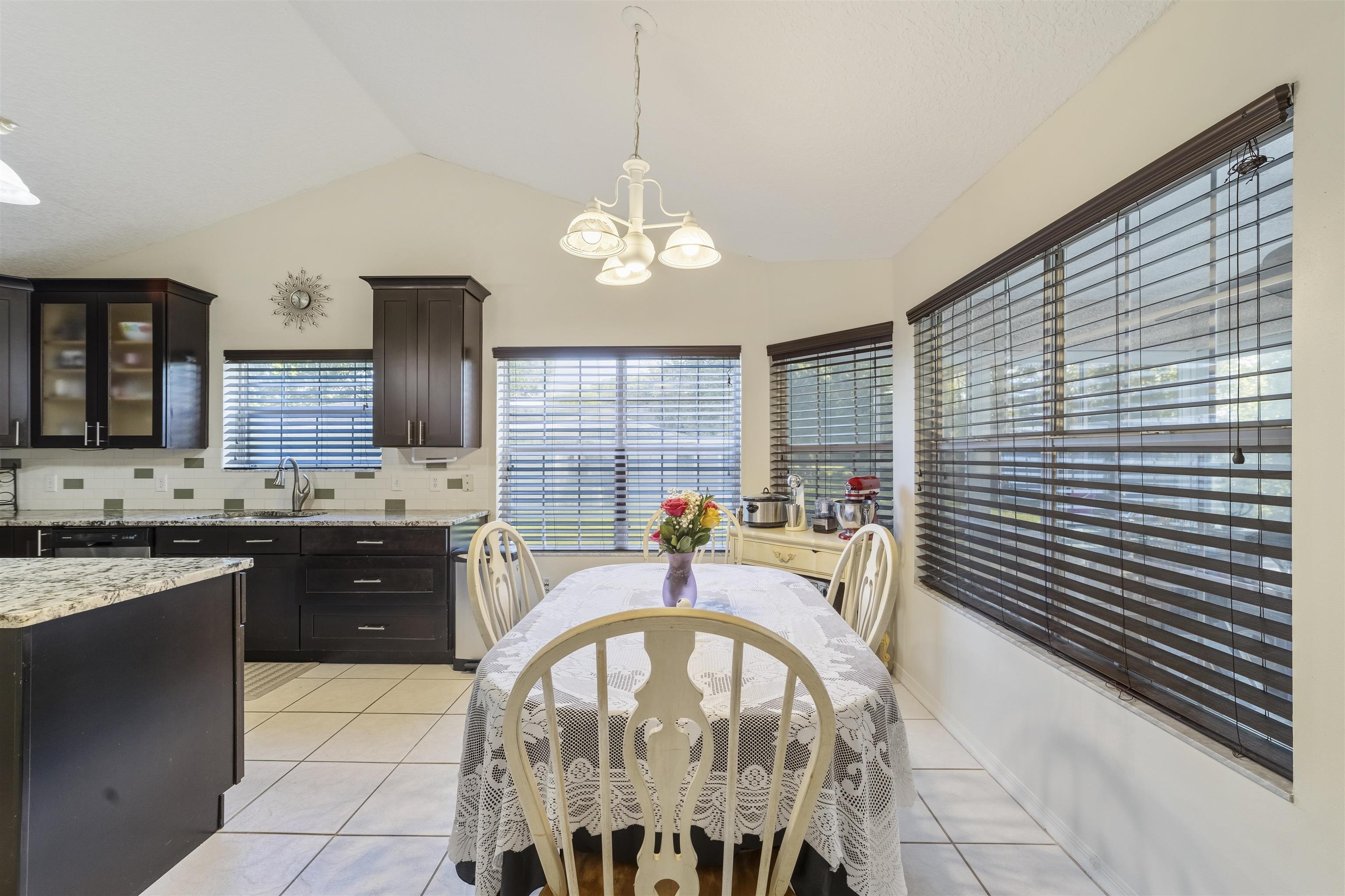 311 Graciela Circle St. Augustine, FL 32086 - Photo 18 of 65 Dining area featuring light tile patterned floors, vaulted ceiling, and a chandelier