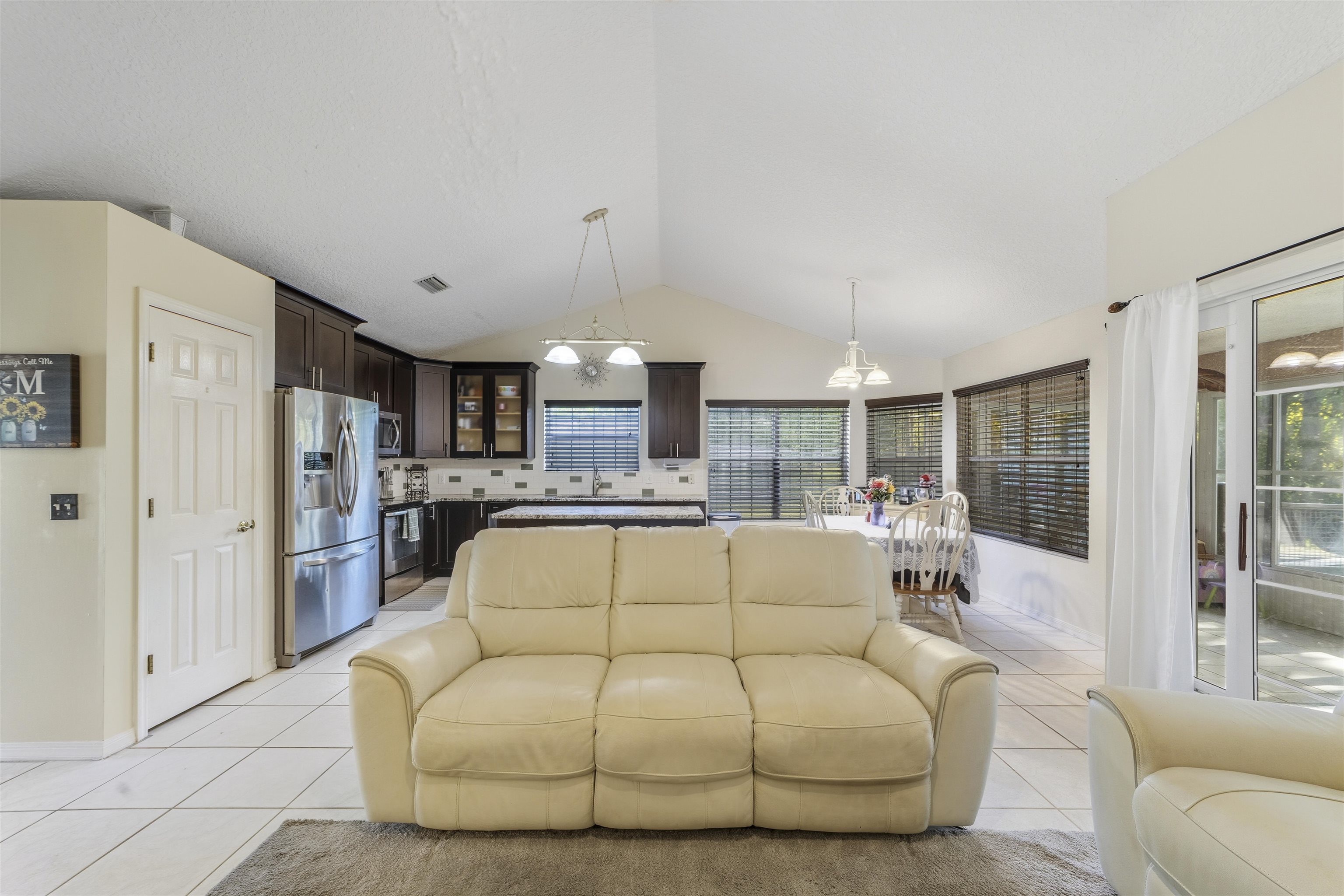311 Graciela Circle St. Augustine, FL 32086 - Photo 19 of 65 Living room featuring light tile patterned floors, lofted ceiling, and a chandelier