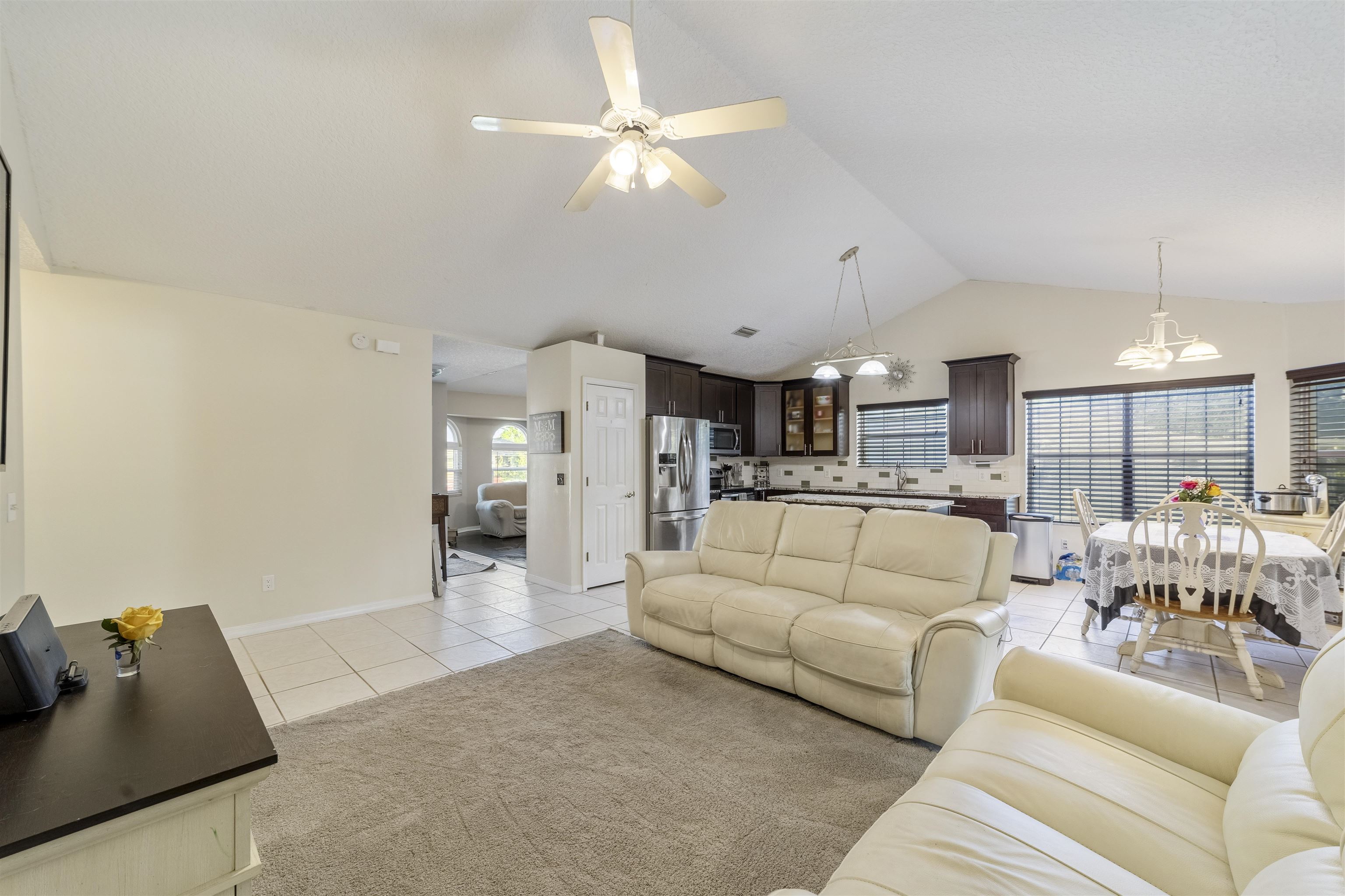 311 Graciela Circle St. Augustine, FL 32086 - Photo 20 of 65 Living room with light tile patterned floors, vaulted ceiling, ceiling fan, and a chandelier