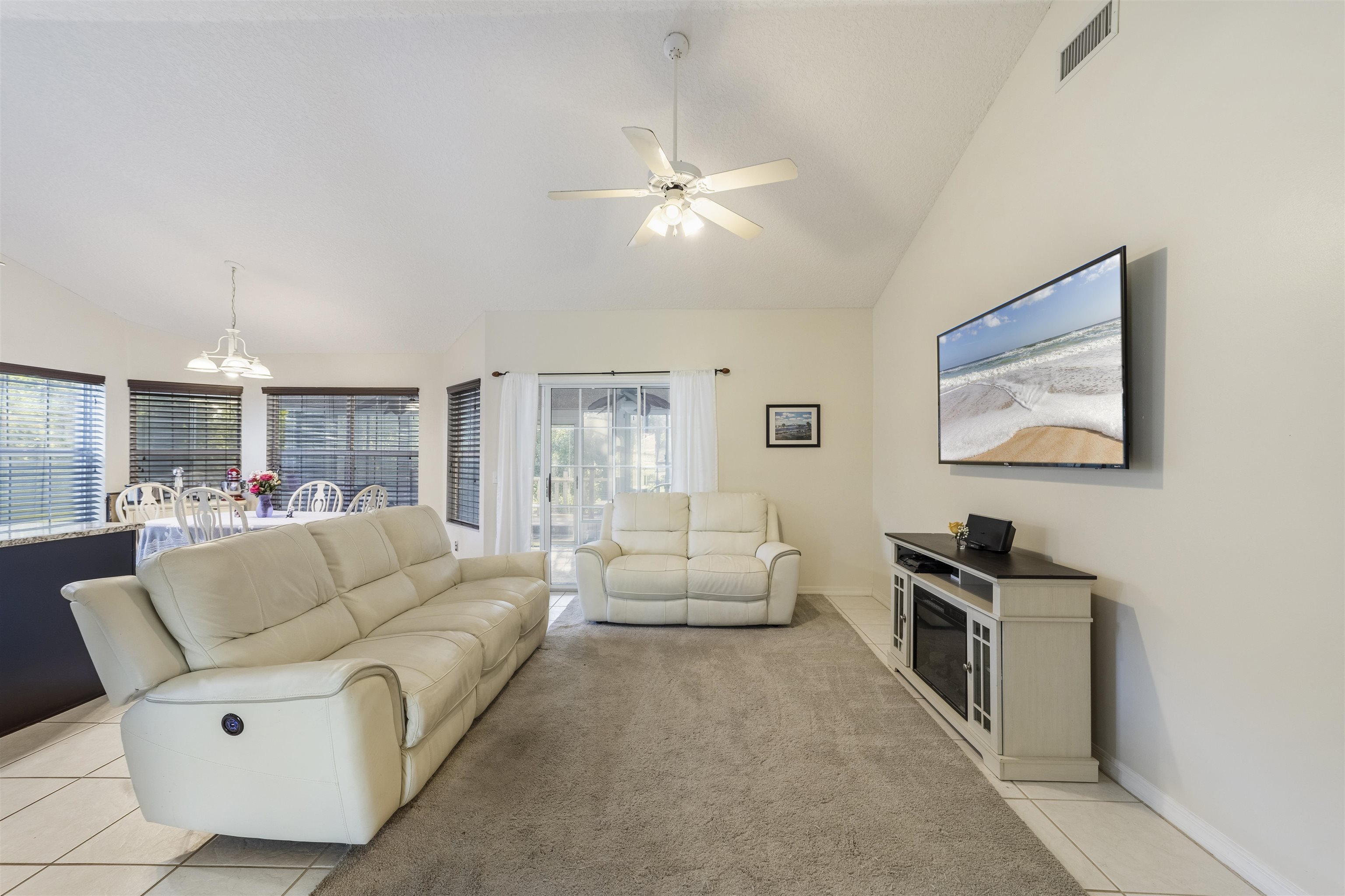 311 Graciela Circle St. Augustine, FL 32086 - Photo 21 of 65 Living area featuring light tile patterned floors, a chandelier, ceiling fan, light colored carpet, and high vaulted ceiling