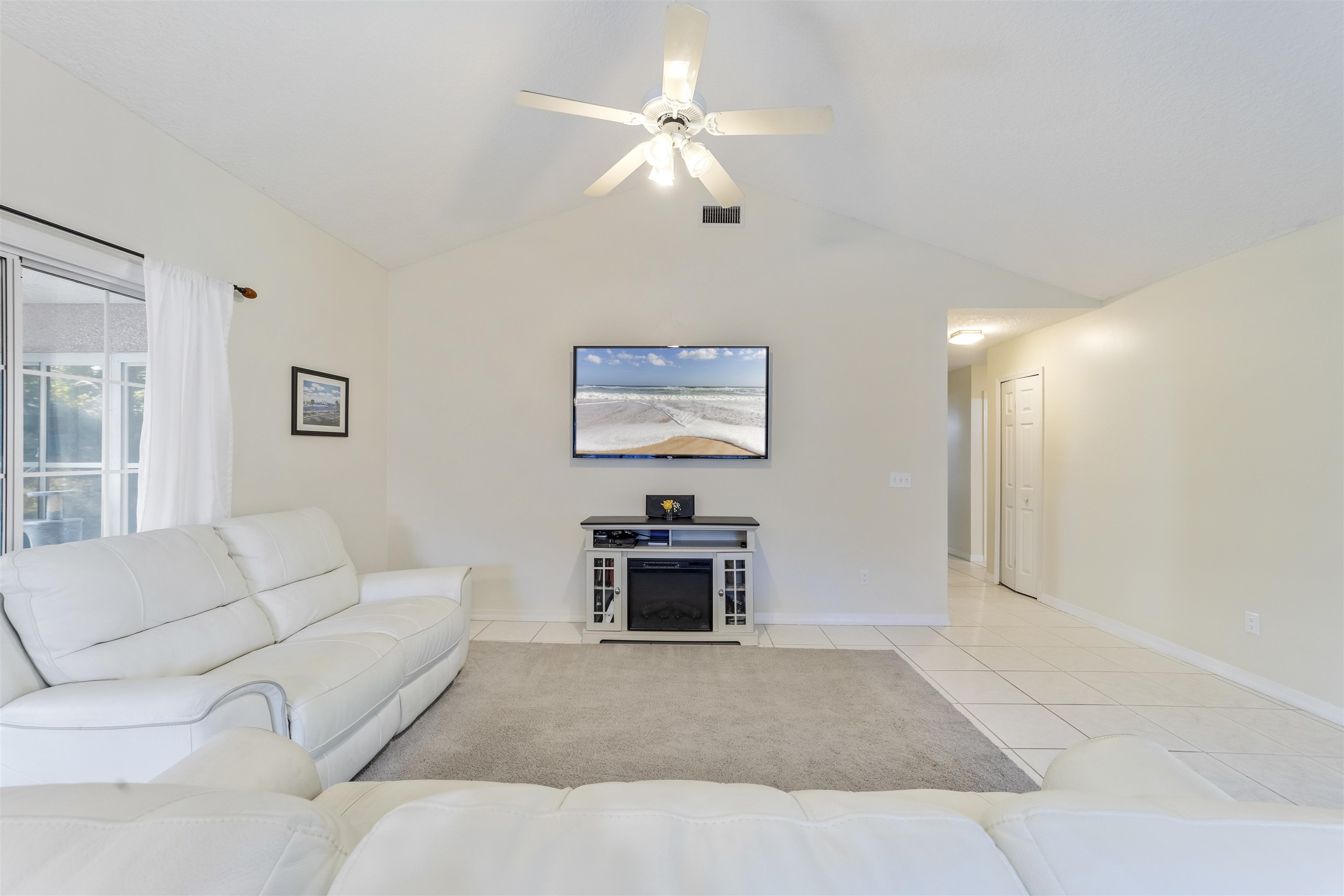 311 Graciela Circle St. Augustine, FL 32086 - Photo 22 of 65 Living area with light tile patterned flooring, vaulted ceiling, and a ceiling fan