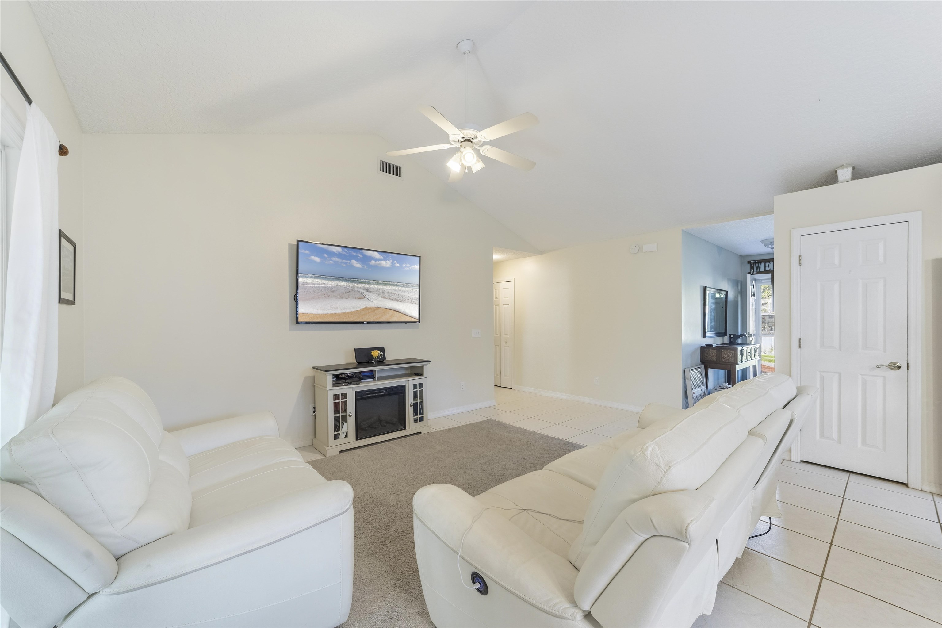 311 Graciela Circle St. Augustine, FL 32086 - Photo 23 of 65 Living area with light tile patterned floors, vaulted ceiling, and a ceiling fan