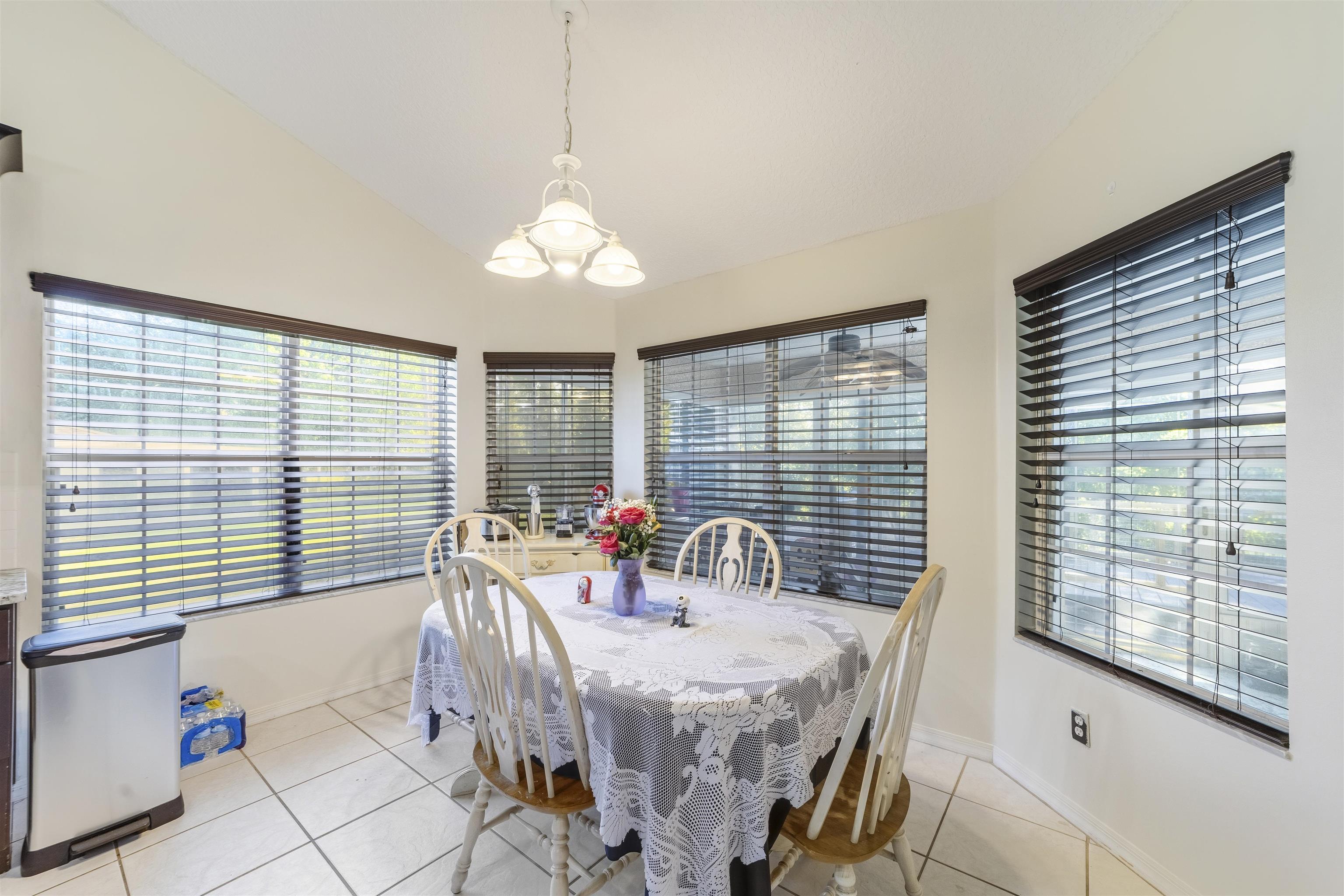 311 Graciela Circle St. Augustine, FL 32086 - Photo 28 of 65 Dining area with light tile patterned floors, a chandelier, and lofted ceiling
