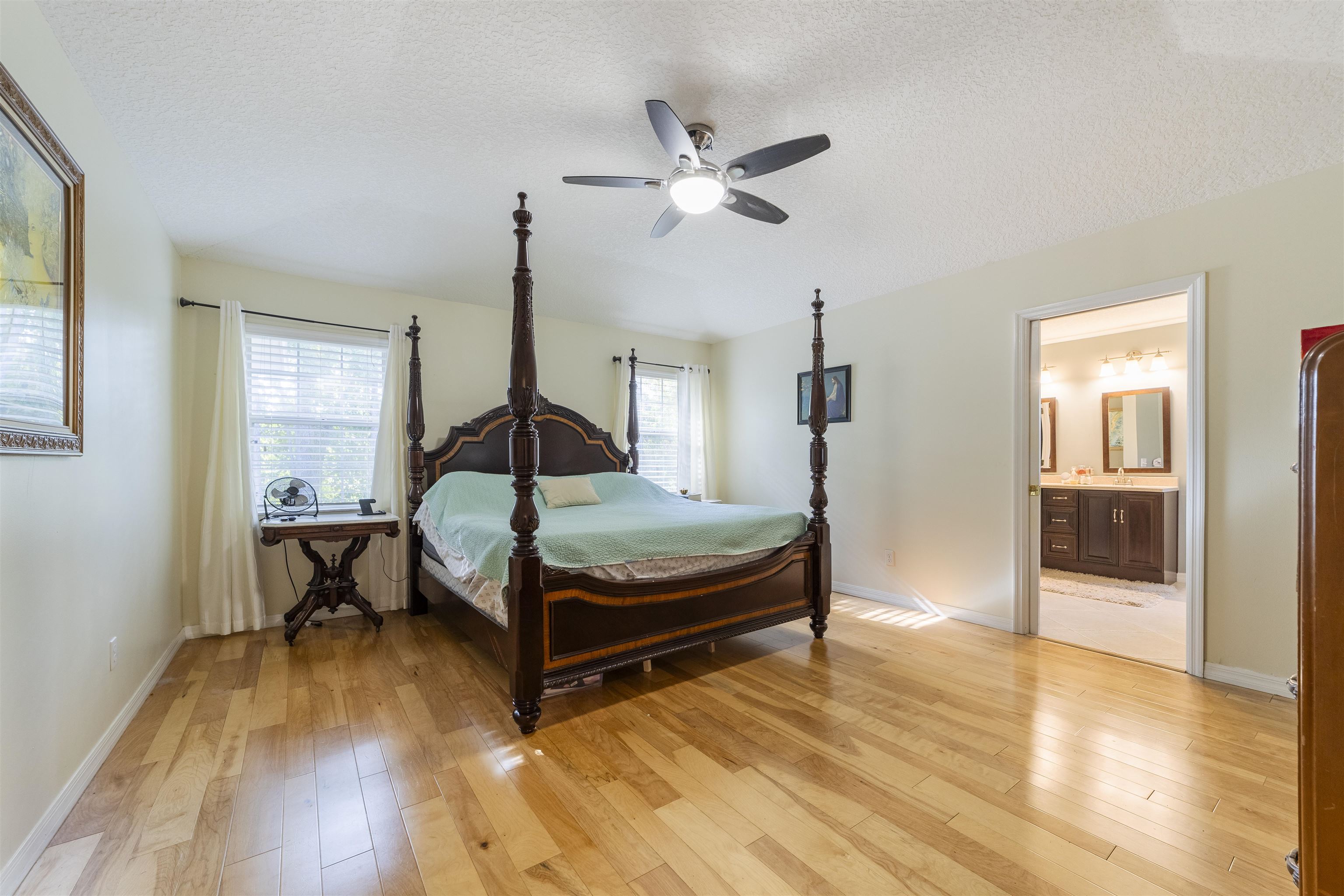 311 Graciela Circle St. Augustine, FL 32086 - Photo 37 of 65 Bedroom with light wood-style flooring, multiple windows, a textured ceiling, ceiling fan, and ensuite bathroom