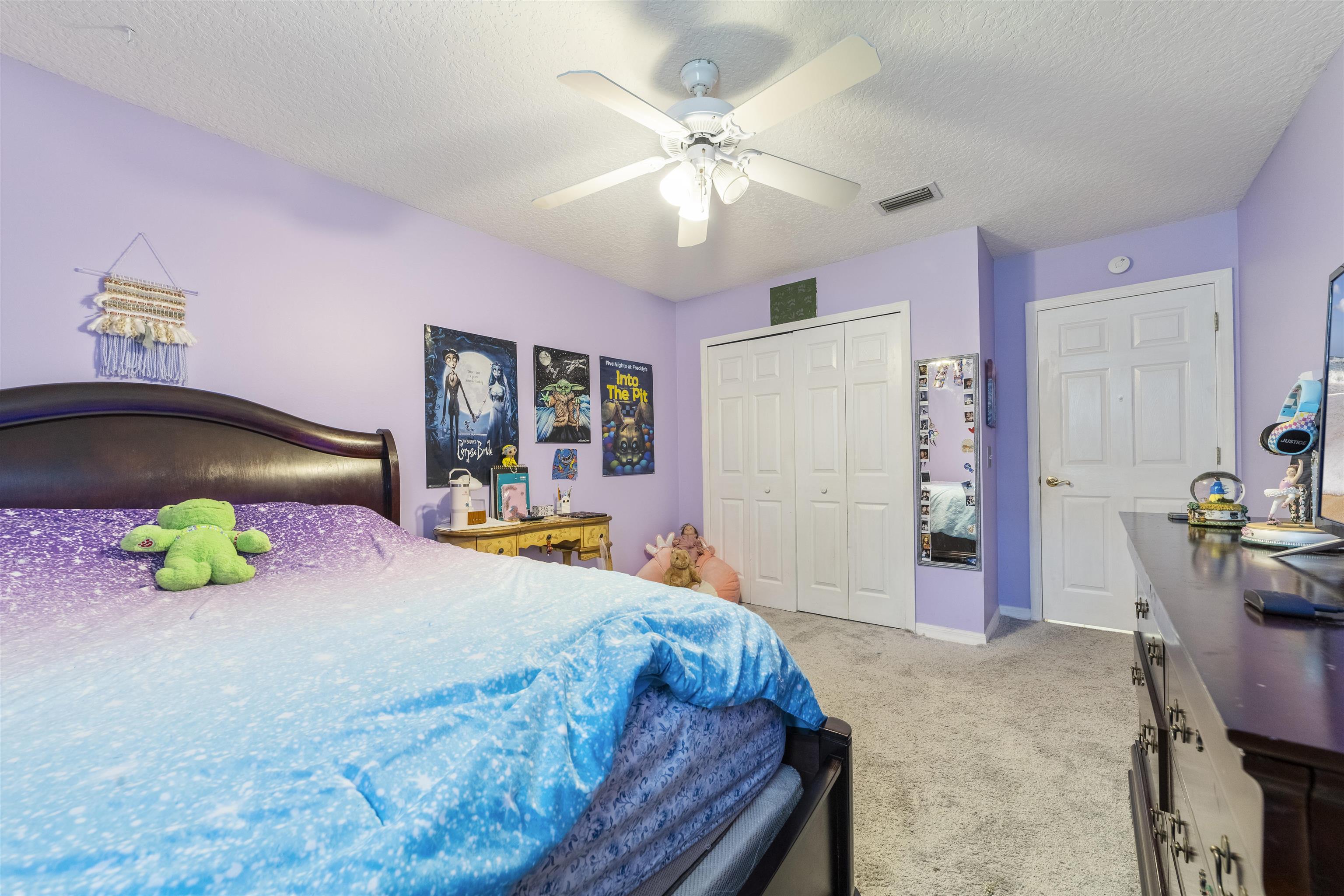 311 Graciela Circle St. Augustine, FL 32086 - Photo 46 of 65 Bedroom featuring light carpet, a textured ceiling, a closet, and a ceiling fan
