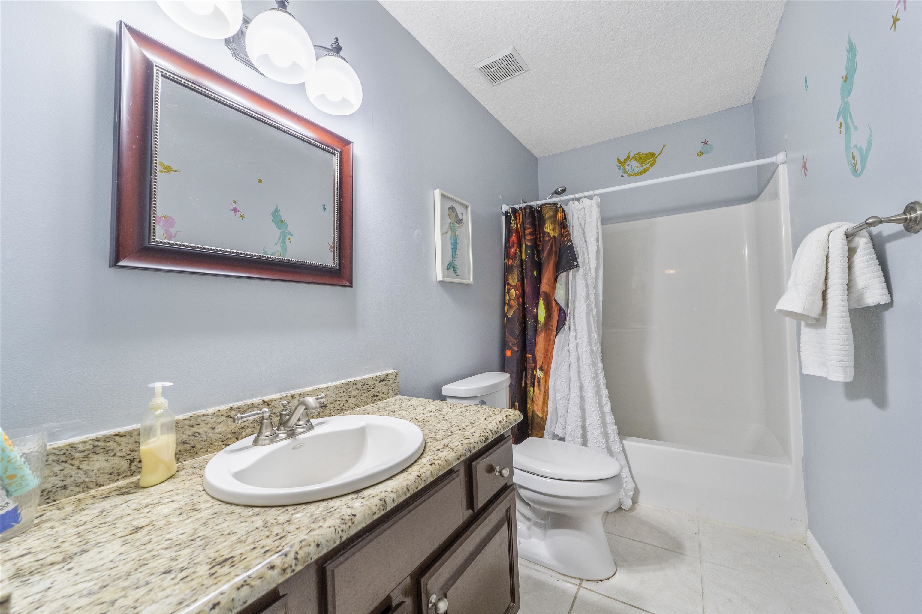 311 Graciela Circle St. Augustine, FL 32086 - Photo 51 of 65 Bathroom with light tile patterned floors, vanity, a textured ceiling, and shower / tub combo with curtain
