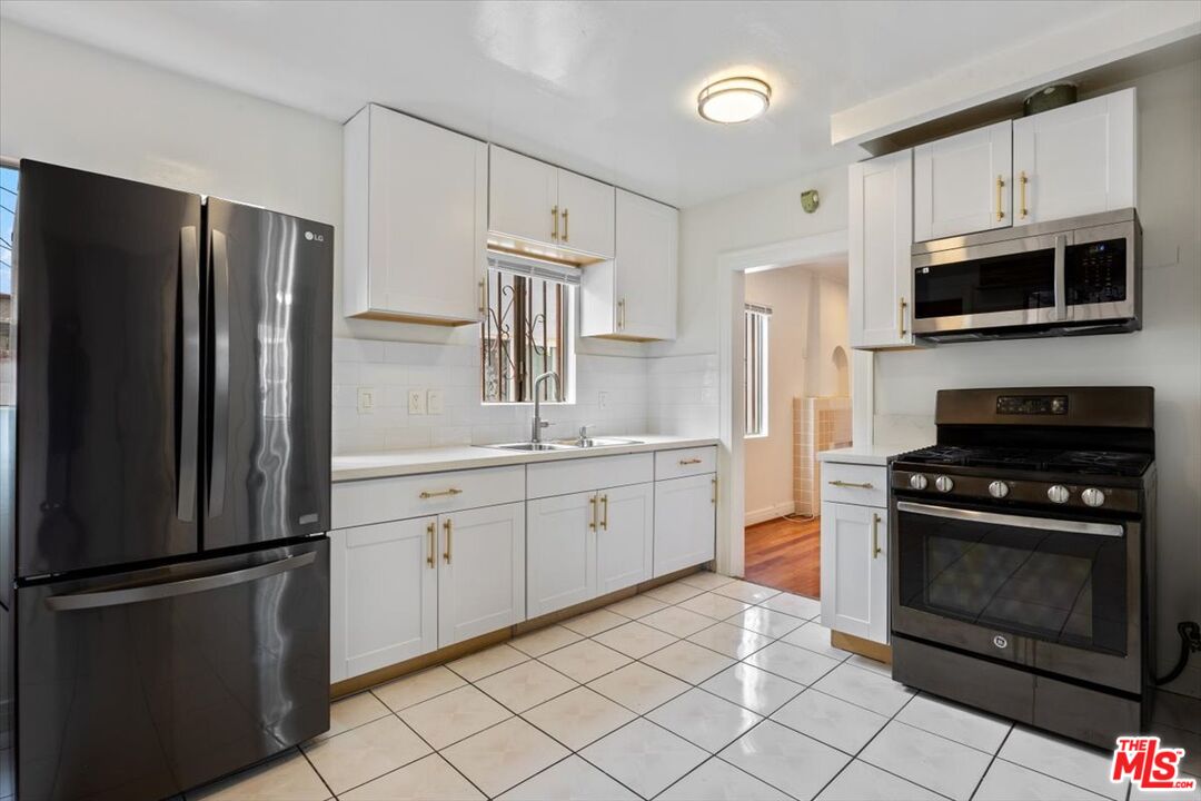 2840 South Mansfield Avenue Los Angeles, CA 90016 - Photo 11 of 50 a kitchen with cabinets stainless steel appliances and a counter space