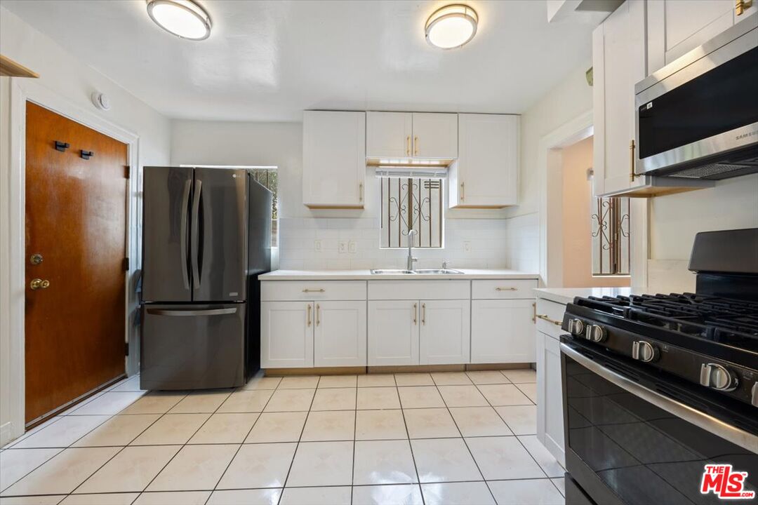 2840 South Mansfield Avenue Los Angeles, CA 90016 - Photo 12 of 50 a kitchen with a stove top oven and refrigerator