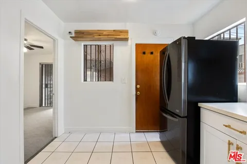 a view of a refrigerator in kitchen and cabinets
