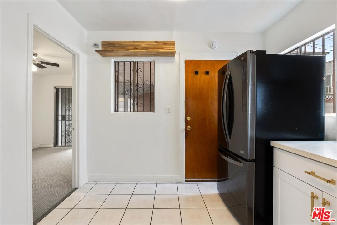 2840 South Mansfield Avenue Los Angeles, CA 90016 - Photo 13 of 50 a view of a refrigerator in kitchen and cabinets