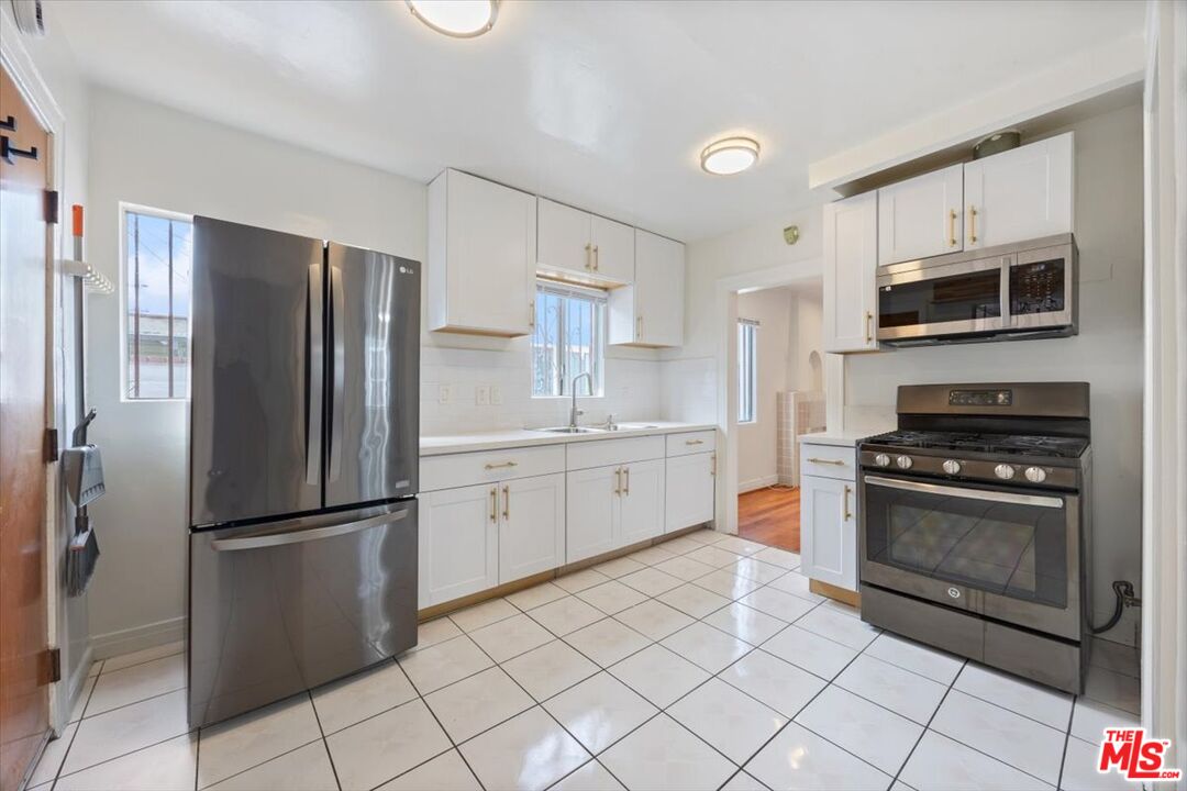 2840 South Mansfield Avenue Los Angeles, CA 90016 - Photo 15 of 50 a kitchen with stainless steel appliances granite countertop a refrigerator sink and stove