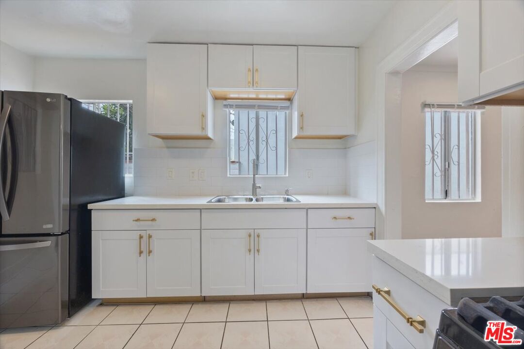 2840 South Mansfield Avenue Los Angeles, CA 90016 - Photo 16 of 50 a kitchen with a sink dishwasher a refrigerator and a stove