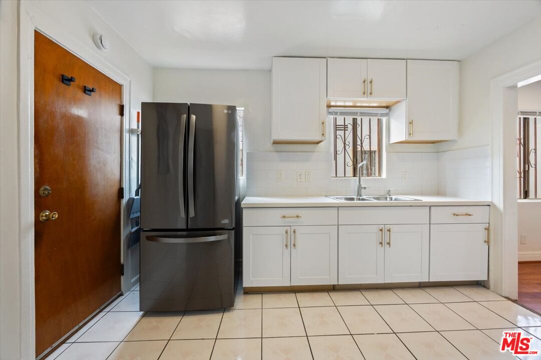 2840 South Mansfield Avenue Los Angeles, CA 90016 - Photo 17 of 50 a kitchen with a refrigerator and cabinets