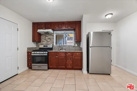 a kitchen with stainless steel appliances granite countertop a refrigerator and a stove