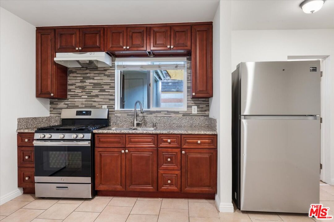 2840 South Mansfield Avenue Los Angeles, CA 90016 - Photo 43 of 50 a kitchen with stainless steel appliances granite countertop a stove and a refrigerator