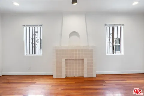 a view of a livingroom with wooden floor and a fireplace