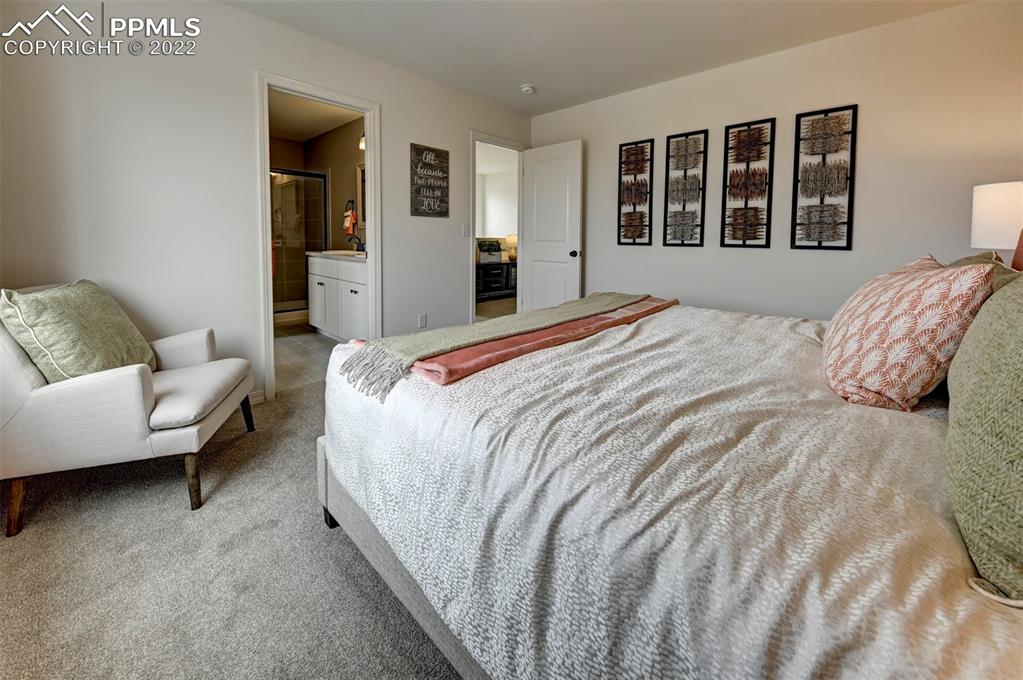 4456 Samaritan Loop Colorado Springs, CO 80916 - Photo 22 of 25 a bedroom with a bed and wooden floor