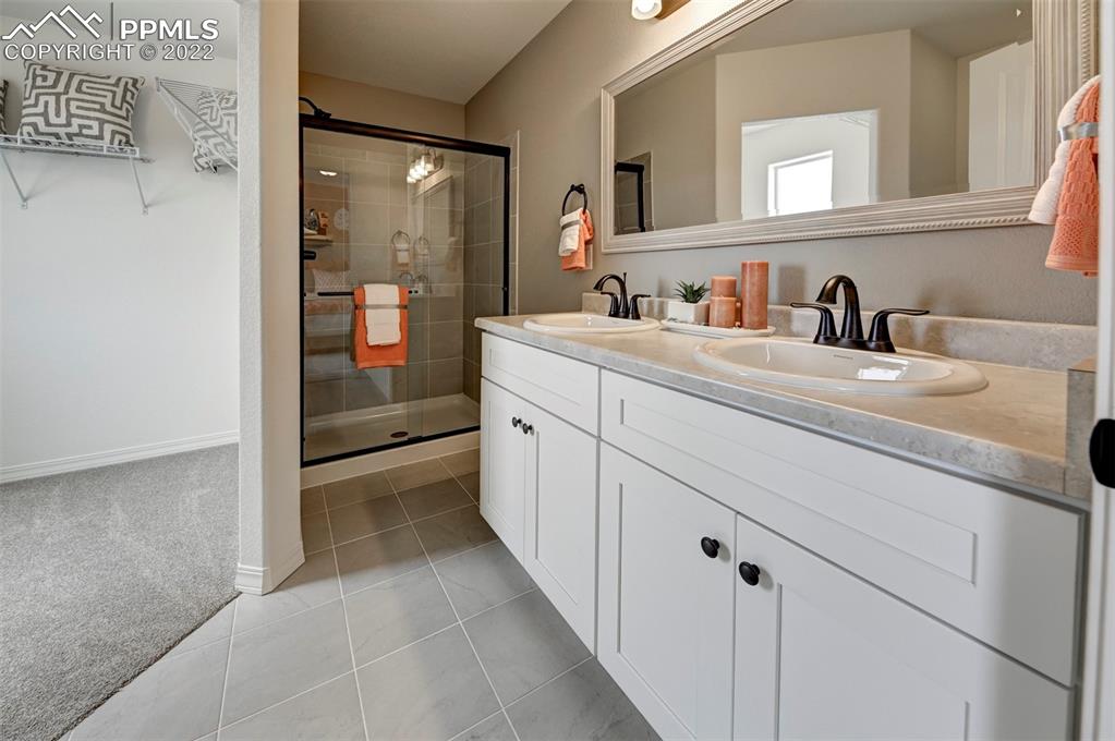 4456 Samaritan Loop Colorado Springs, CO 80916 - Photo 24 of 25 a spacious bathroom with a sink and a mirror