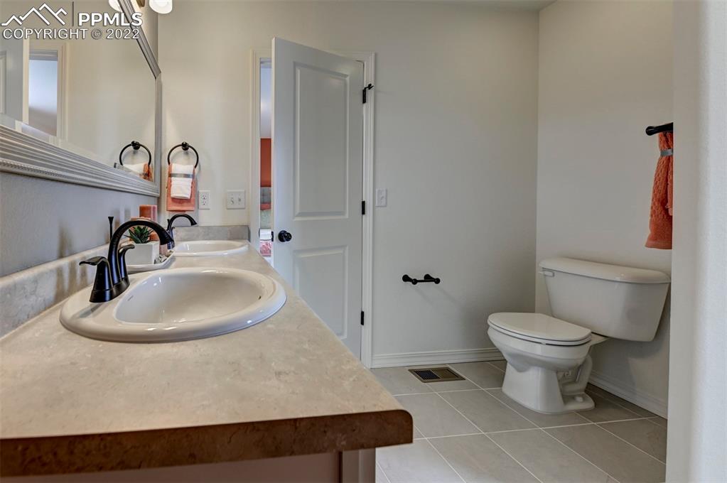 4456 Samaritan Loop Colorado Springs, CO 80916 - Photo 25 of 25 a bathroom with a sink toilet and mirror