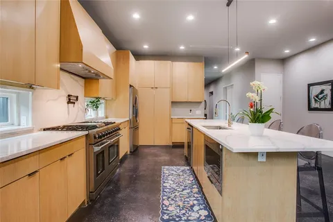 a kitchen with stainless steel appliances granite countertop a sink a stove and a refrigerator