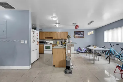 a living room with furniture a dining table and kitchen view