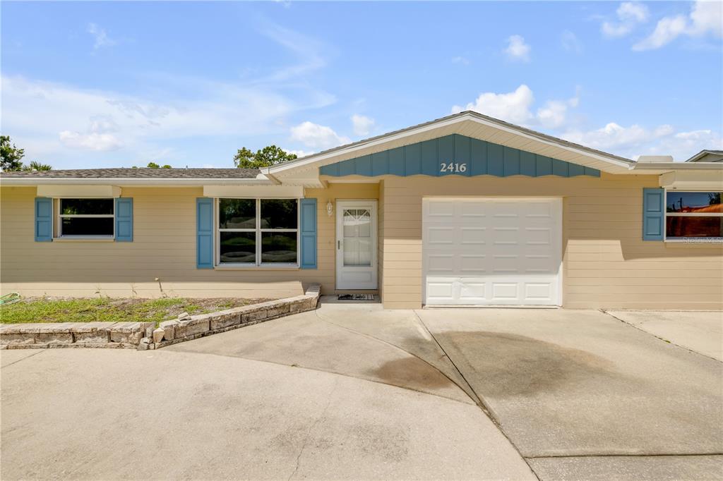 2416 Pine Tree Drive Edgewater, FL 32141 - Photo 11 of 50 a front view of a house with a yard and garage