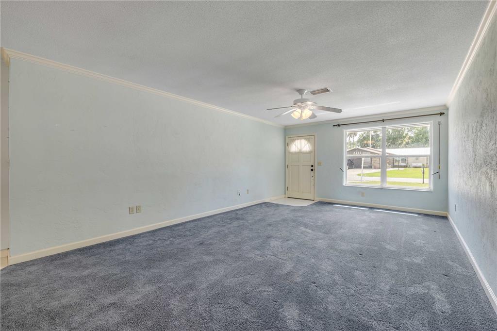 2416 Pine Tree Drive Edgewater, FL 32141 - Photo 17 of 50 an empty room with a window and fireplace