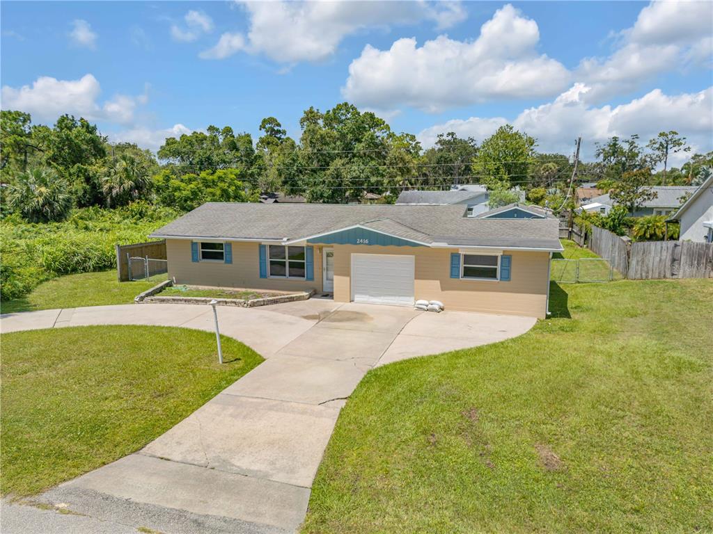 2416 Pine Tree Drive Edgewater, FL 32141 - Photo 2 of 50 a front view of a house with yard patio and green space