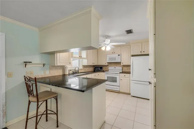 a kitchen with stainless steel appliances granite countertop a sink refrigerator and cabinets