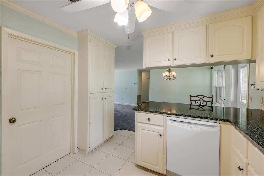 2416 Pine Tree Drive Edgewater, FL 32141 - Photo 28 of 50 a kitchen with granite countertop white cabinets and white appliances
