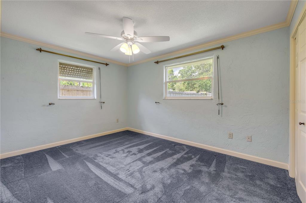 2416 Pine Tree Drive Edgewater, FL 32141 - Photo 29 of 50 an empty room with windows and fan