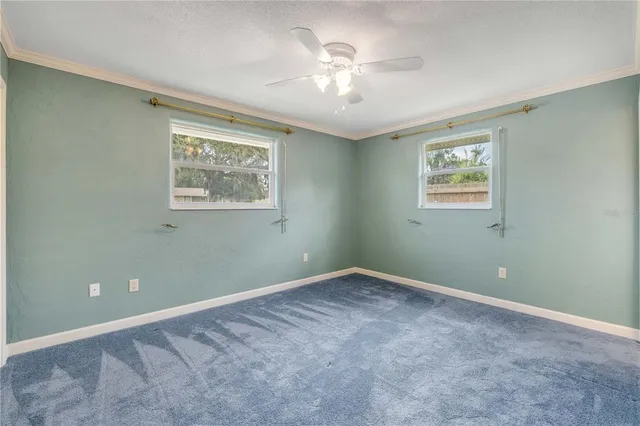 a view of an empty room with a ceiling fan