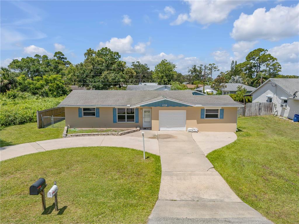2416 Pine Tree Drive Edgewater, FL 32141 - Photo 4 of 50 a front view of a house with a garden
