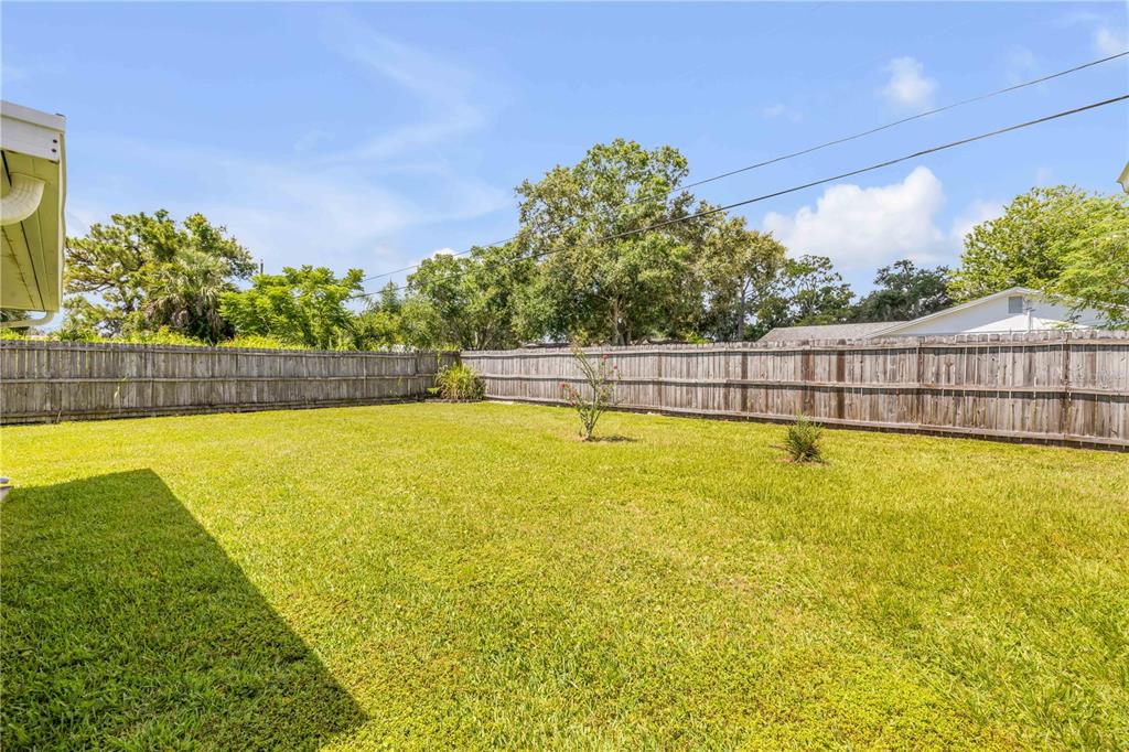 2416 Pine Tree Drive Edgewater, FL 32141 - Photo 43 of 50 a view of a swimming pool with an outdoor seating and a garden