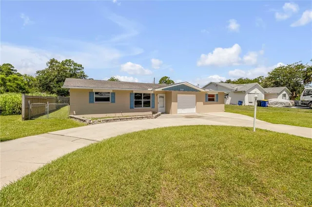 a white house with a large pool and yard