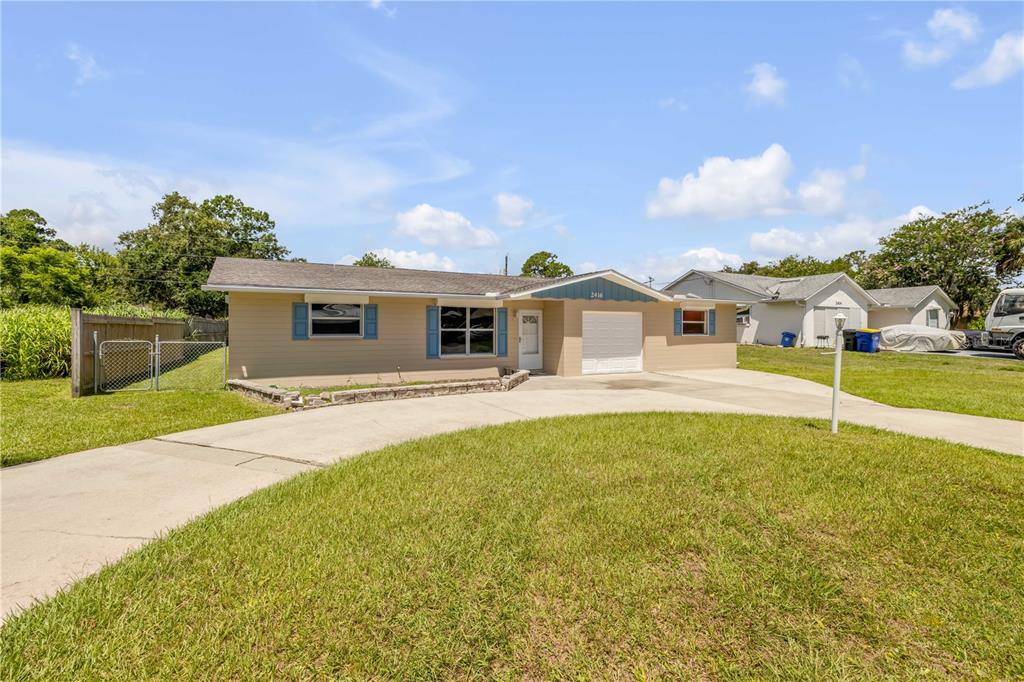 2416 Pine Tree Drive Edgewater, FL 32141 - Photo 8 of 50 a white house with a large pool and yard