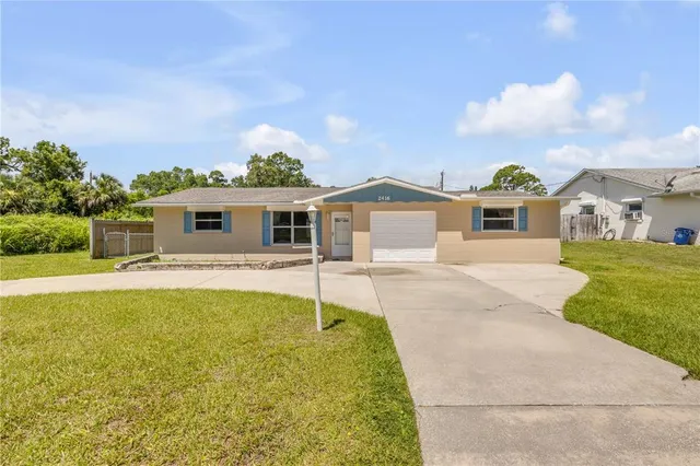 a backyard of a house with table and chairs