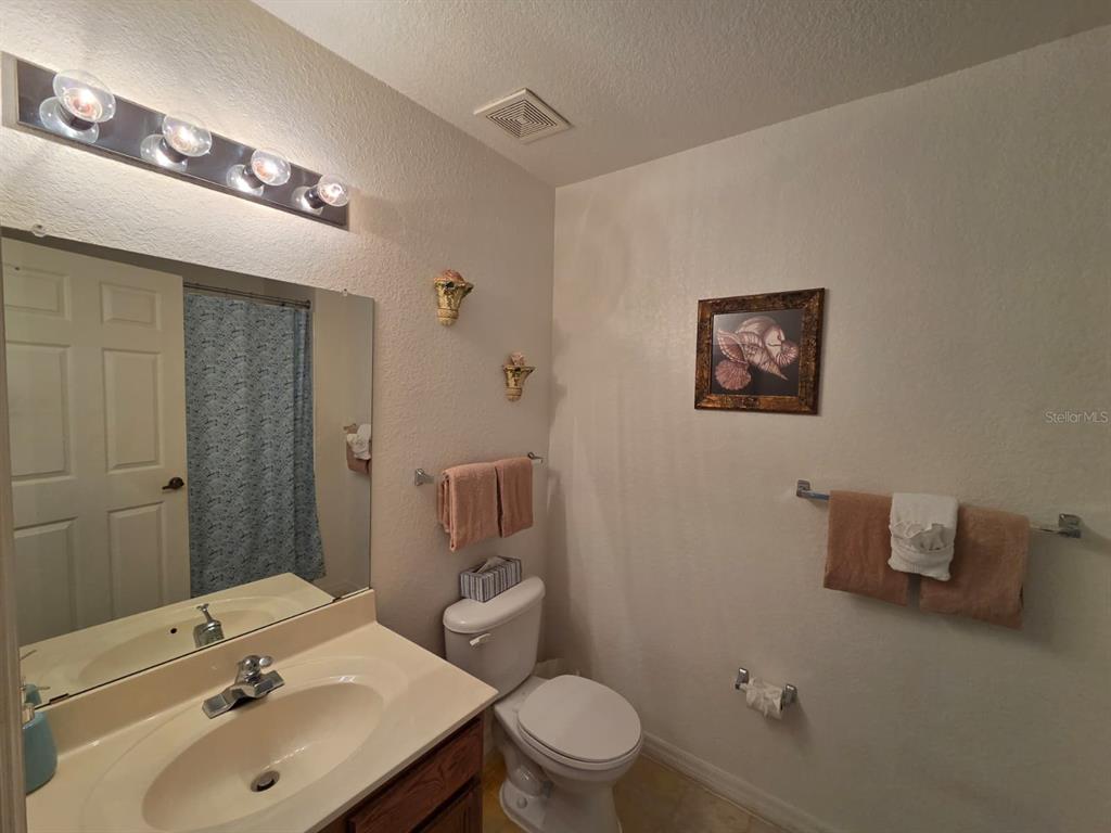 4600 Yellowgold Road West, Unit 106 Kissimmee, FL 34746 - Photo 12 of 25 a bathroom with a sink mirror and toilet