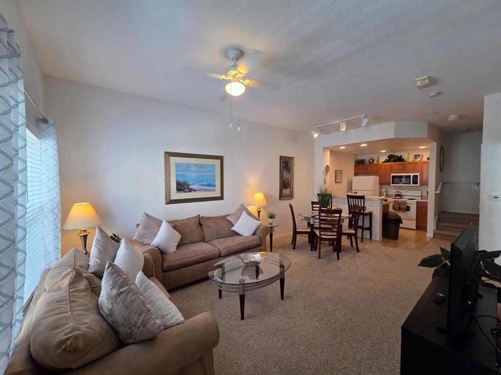 4600 Yellowgold Road West, Unit 106 Kissimmee, FL 34746 - Photo 6 of 25 a living room with furniture and a chandelier