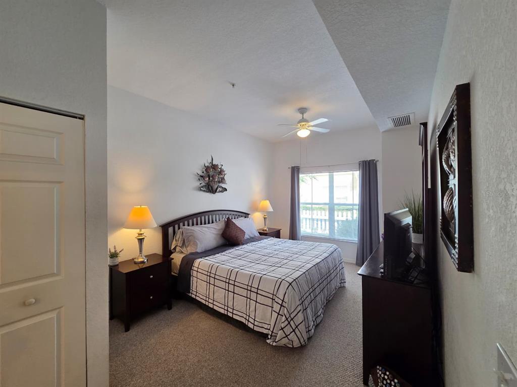 4600 Yellowgold Road West, Unit 106 Kissimmee, FL 34746 - Photo 7 of 25 a bedroom with a bed and a lamp
