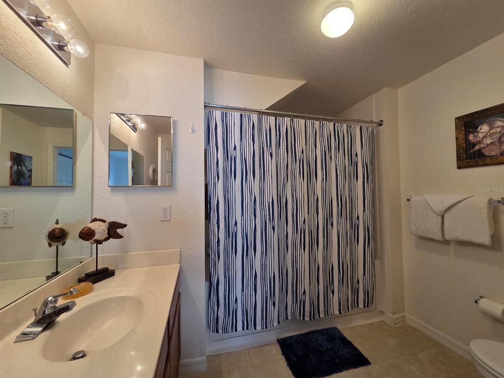 4600 Yellowgold Road West, Unit 106 Kissimmee, FL 34746 - Photo 8 of 25 a bathroom with a sink a toilet and mirror