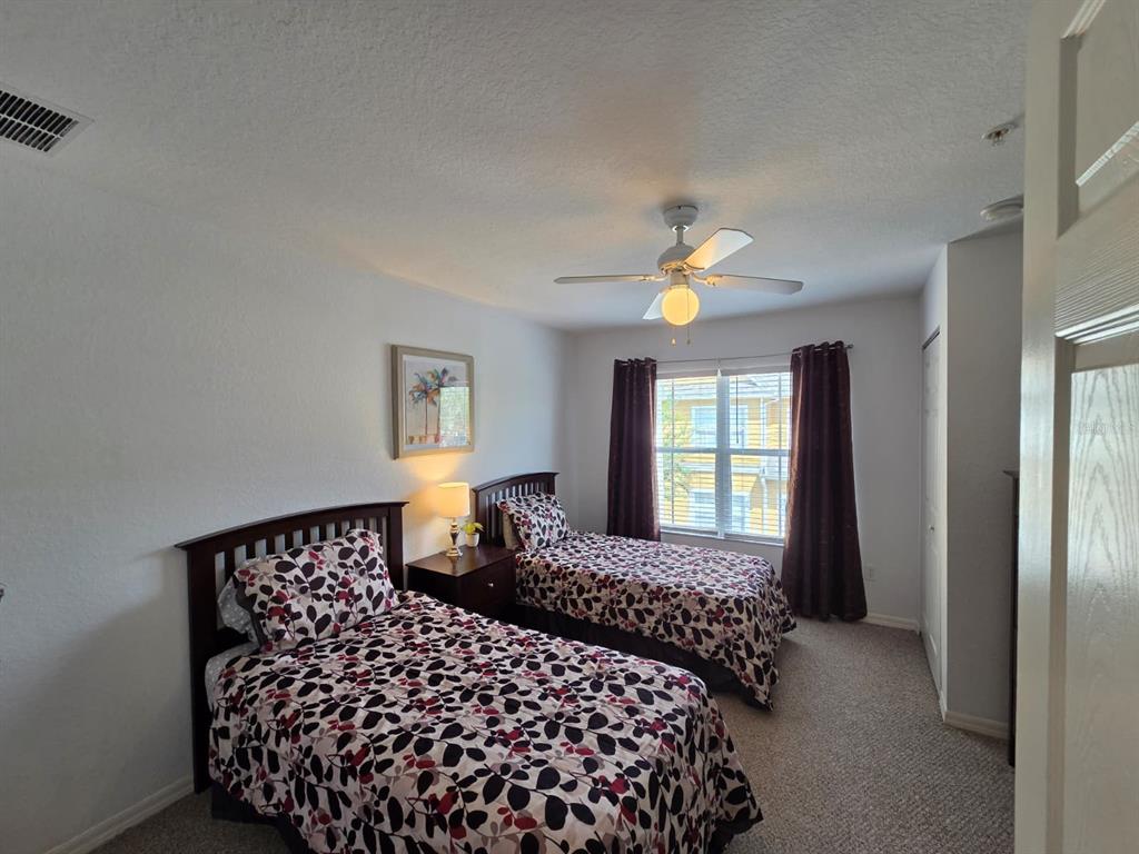 4600 Yellowgold Road West, Unit 106 Kissimmee, FL 34746 - Photo 10 of 25 a bedroom with a large bed and a chandelier