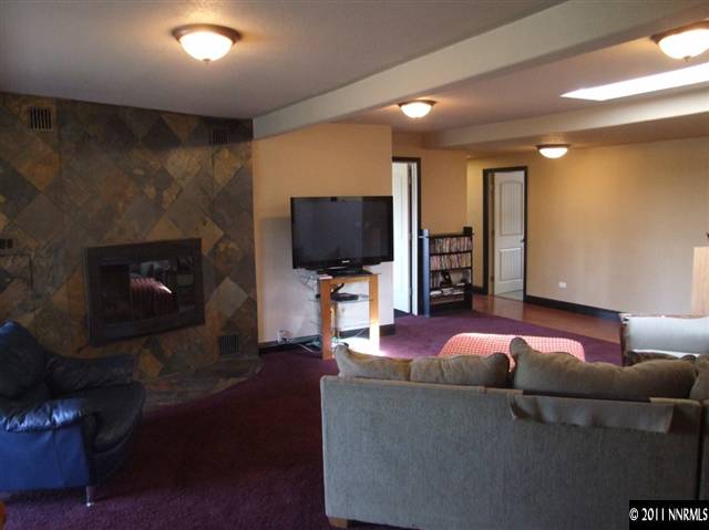 15165 Kivett Lane Reno, NV 89521 - Photo 2 of 12 a living room with furniture a fireplace and a flat screen tv