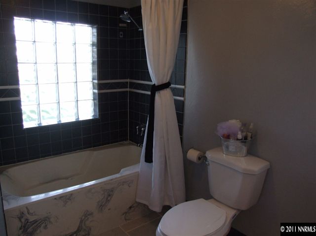 15165 Kivett Lane Reno, NV 89521 - Photo 9 of 12 a bathroom with a sink toilet and window