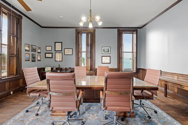 a view of a dining room with furniture a chandelier and wooden floor