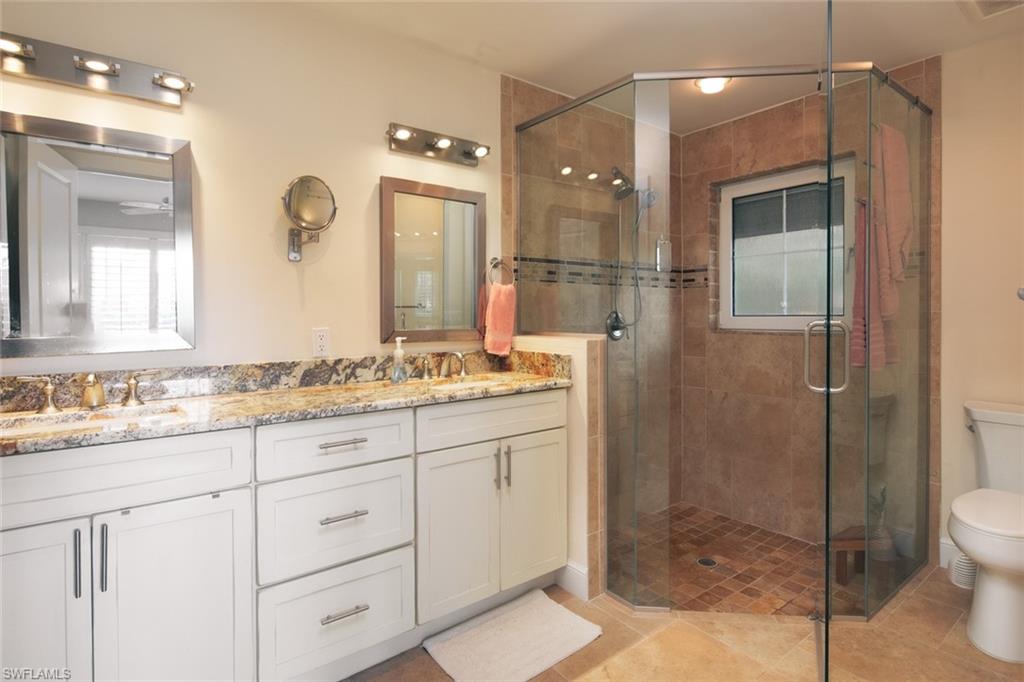 2155 Tarpon Road Naples, FL 34102 - Photo 18 of 27 a bathroom with a granite countertop sink mirror and shower
