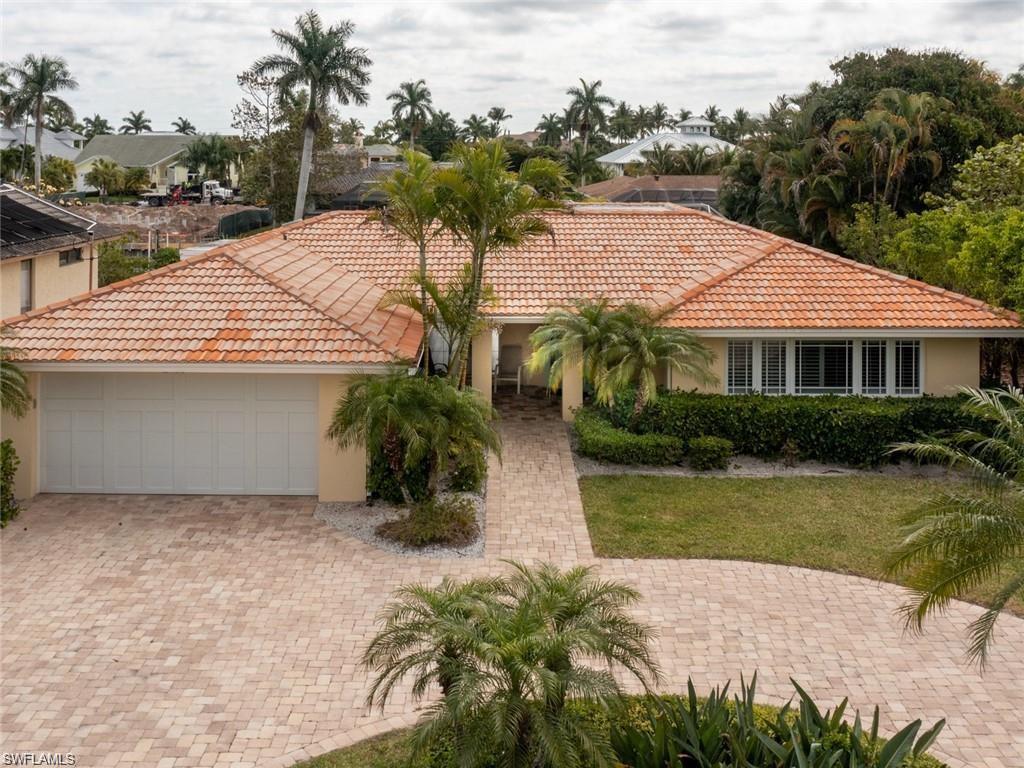2155 Tarpon Road Naples, FL 34102 - Photo 25 of 27 a view of a house with a yard and potted plants